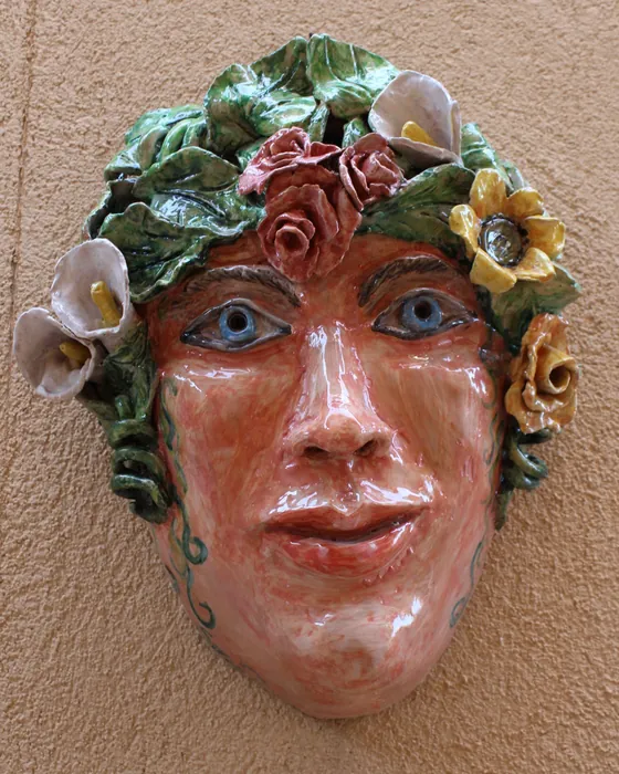 Maschera da parete volto con corona di fiori, ceramica dipinta a mano da Elvira Sirio
