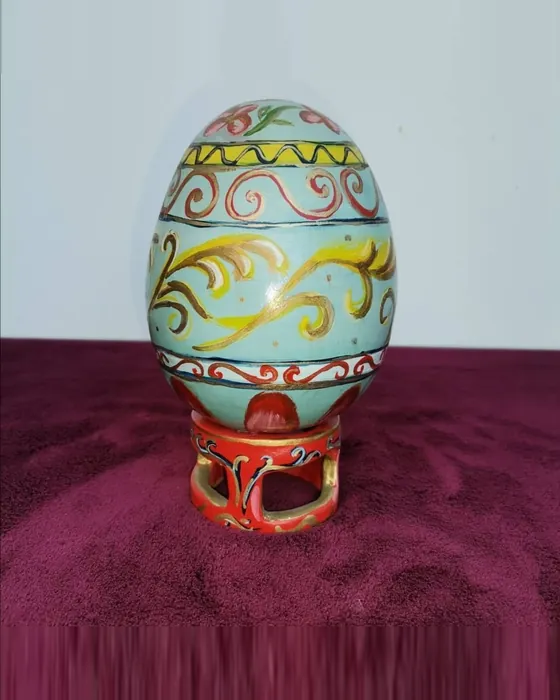 Uovo decorato azzurro su base rossa, ceramica dipinta a mano da Elvira Sirio
